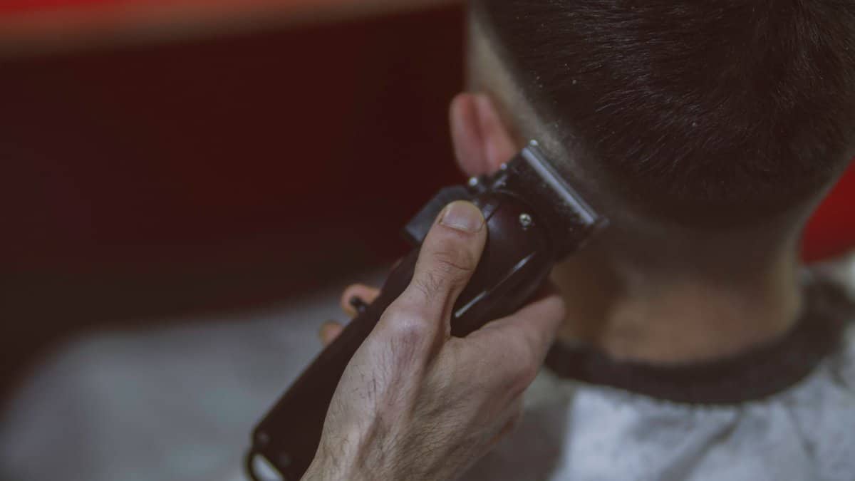 Close-up view of a man getting a haircut with clippers, highlighting the precise technique.