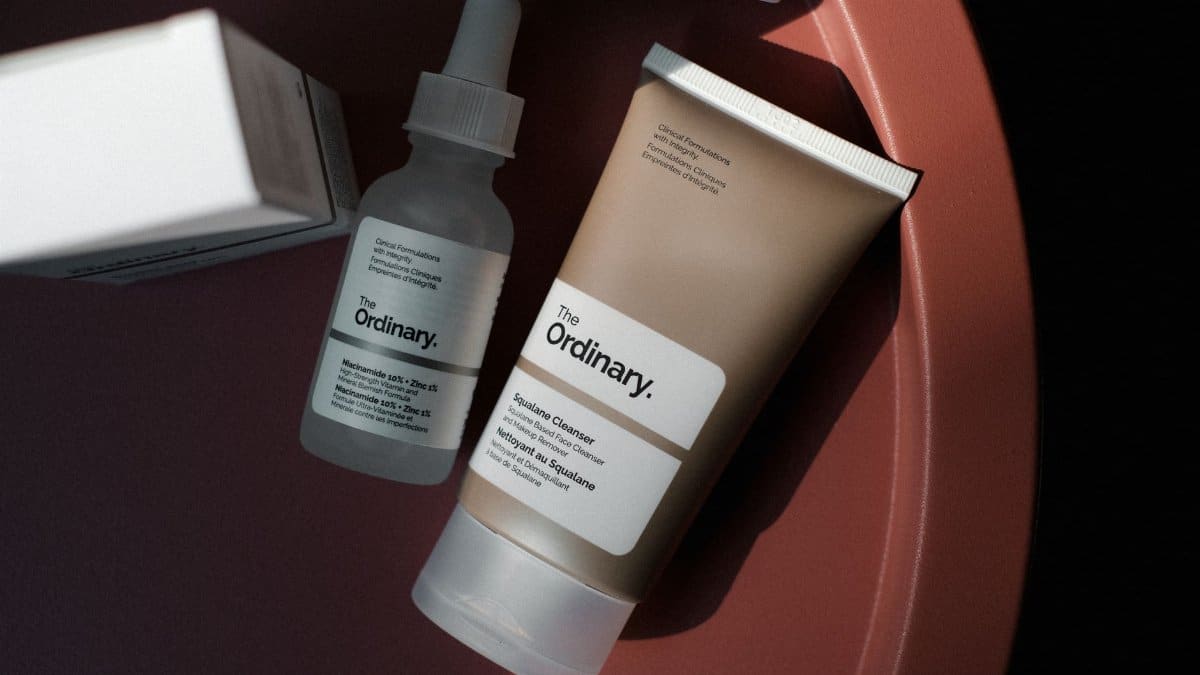 Chic minimalist shot of The Ordinary skincare products on a rose-colored background.