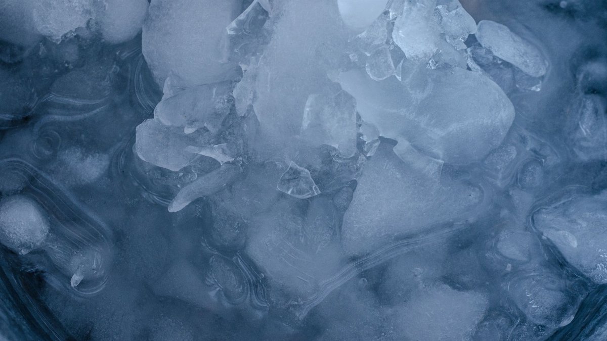 Detailed macro shot of ice crystals slowly melting, showcasing intricate patterns and textures.