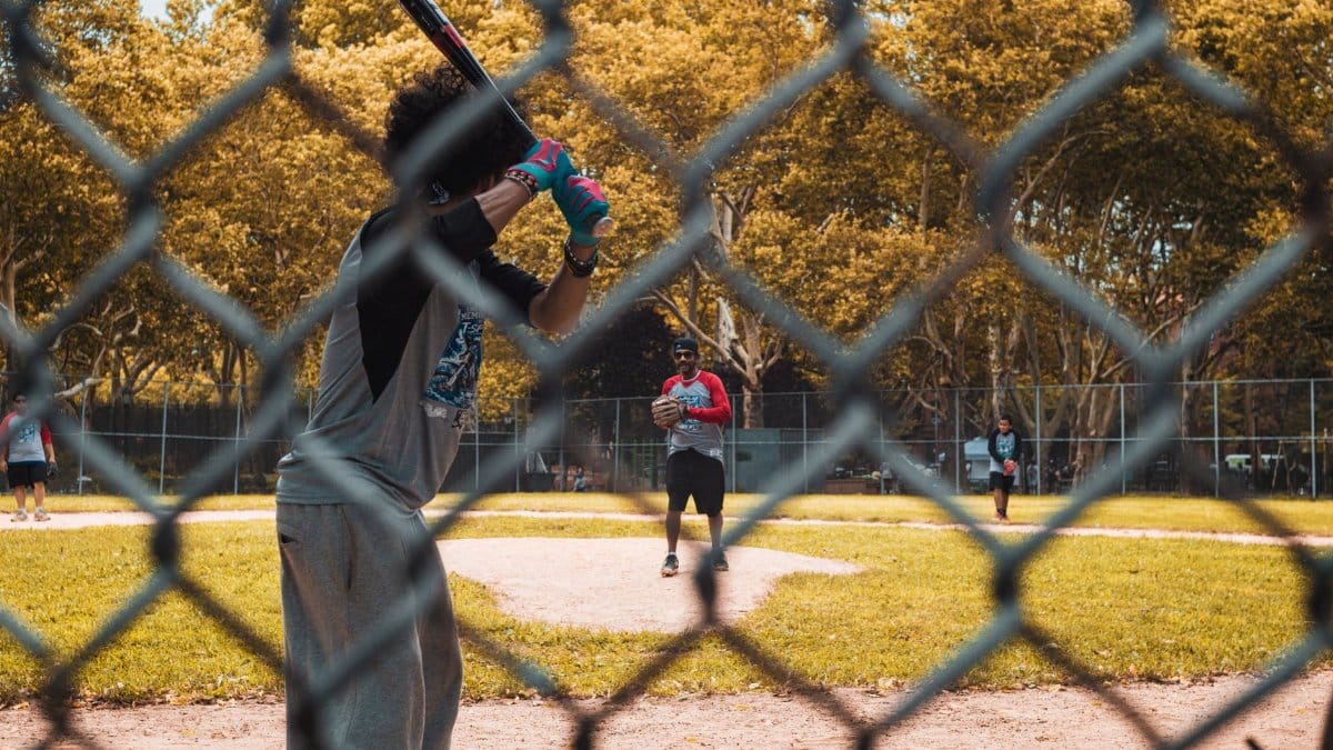 Casual baseball game at a New York City park, showcasing players in action and vibrant autumn scenery.