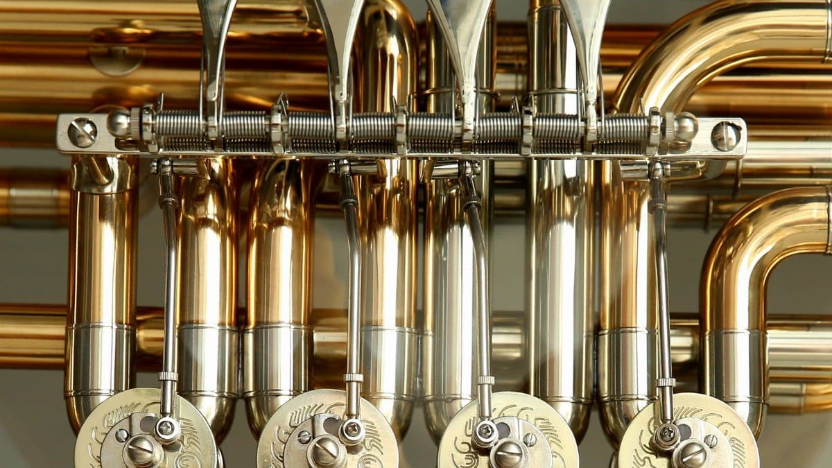 Detailed close-up of shiny brass musical instrument valves showcasing intricate metalwork.