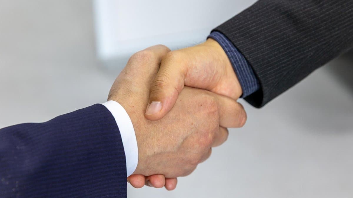 Close-up of two businessmen shaking hands, symbolizing agreement and partnership.