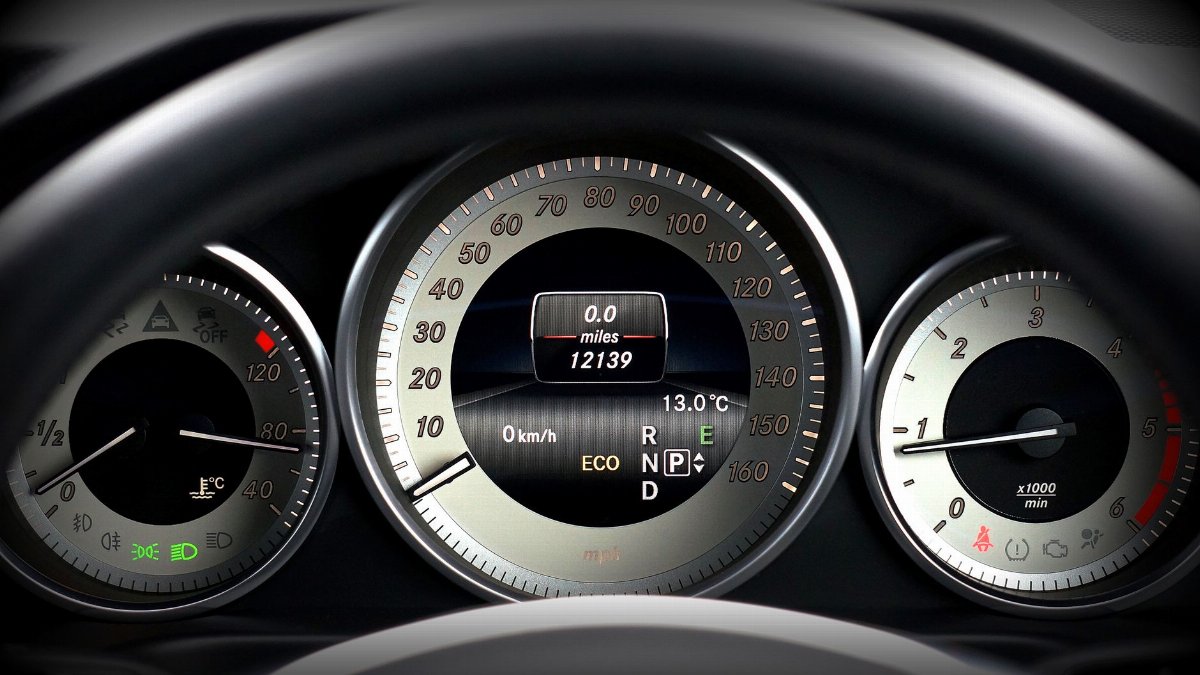 Close-up image of a car dashboard highlighting speedometer, odometer, and temperature gauge.