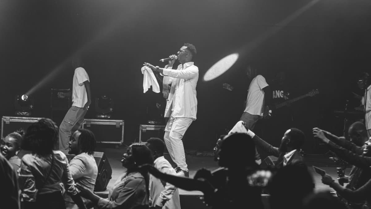 Black and white image capturing a dynamic live music performance on stage.