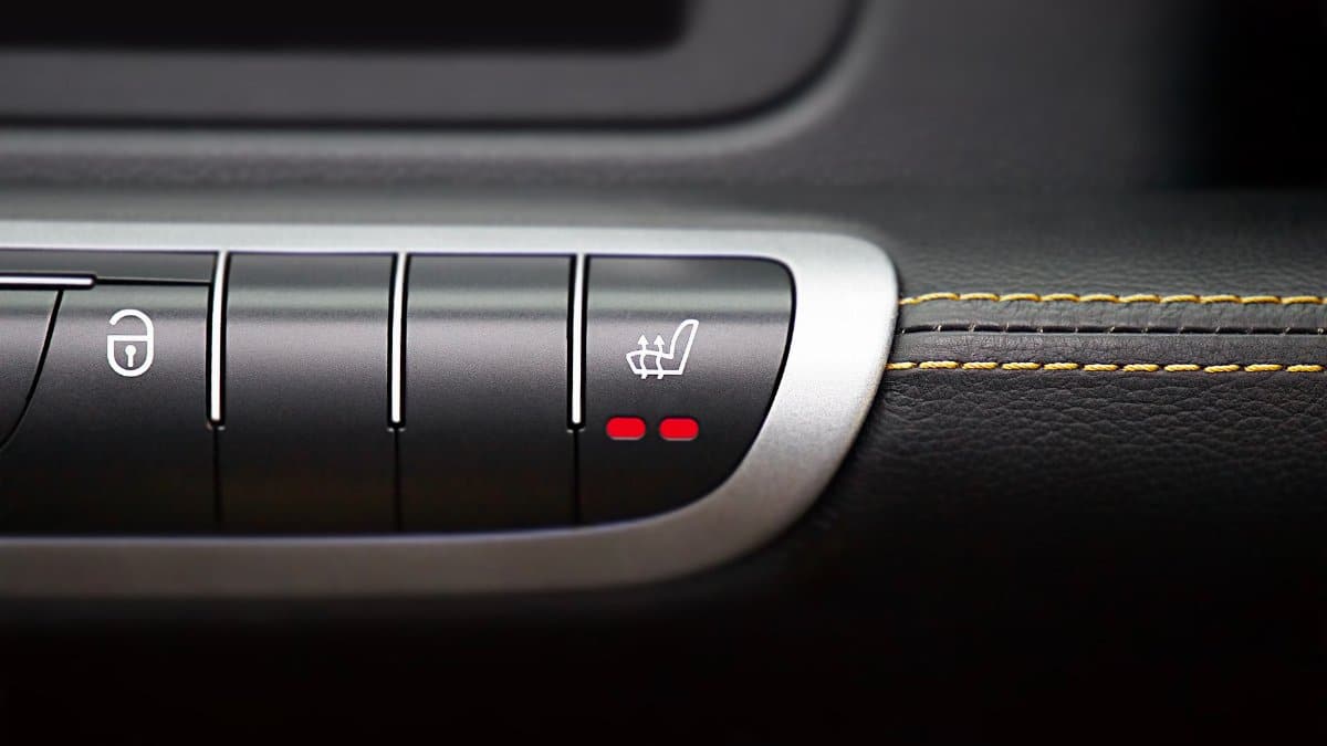Close-up of modern car interior control panel featuring heated seat and central locking buttons.