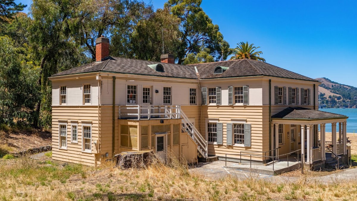 Old mansion at Angel Island State Park with ocean view and natural landscape under clear blue sky.