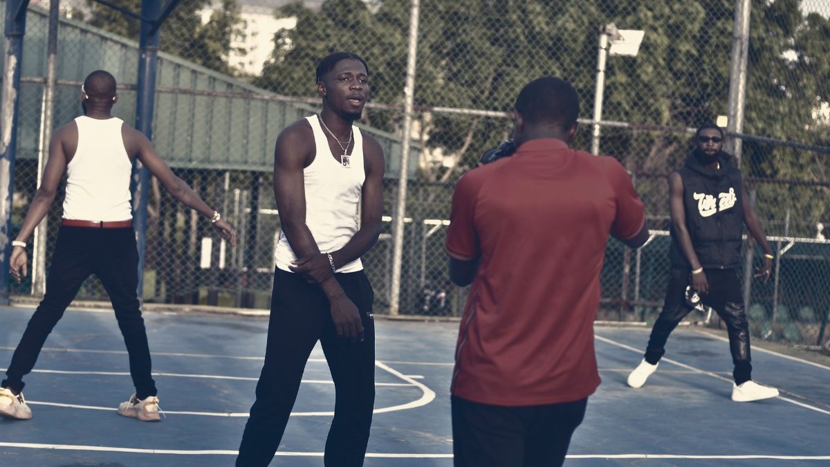 Group of young men posing and playing on an outdoor basketball court, capturing dynamic sports moments.