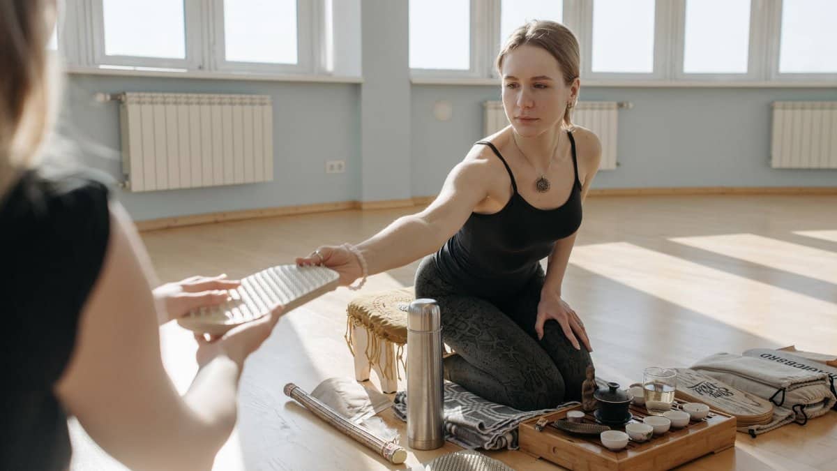 A woman engaging in a wellness practice with a tea ceremony, indoors, enhancing well-being.