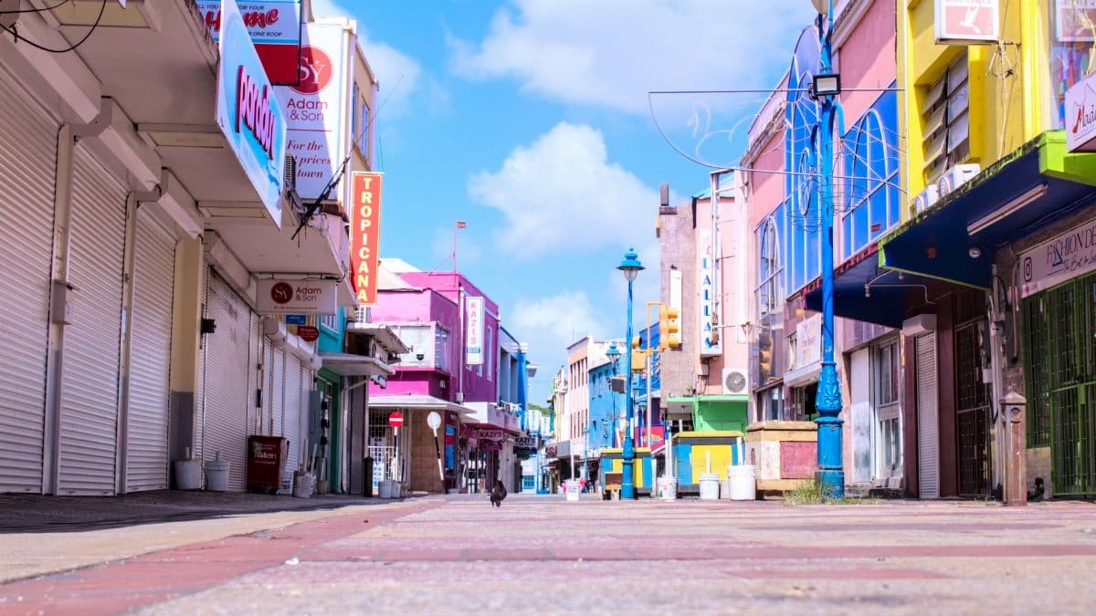 Vibrant downtown street in Bridgetown, Barbados with colorful buildings and a clear blue sky.