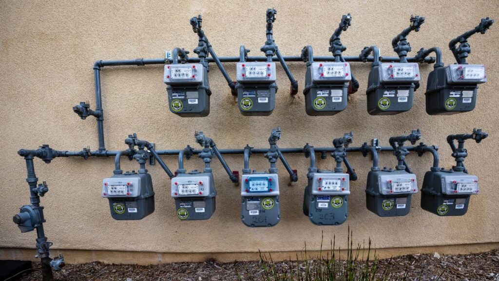 A neat installation of gas meters mounted on an exterior wall in an urban setting.