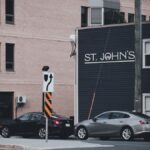 City street view featuring St. John's sign, cars, and urban architecture.
