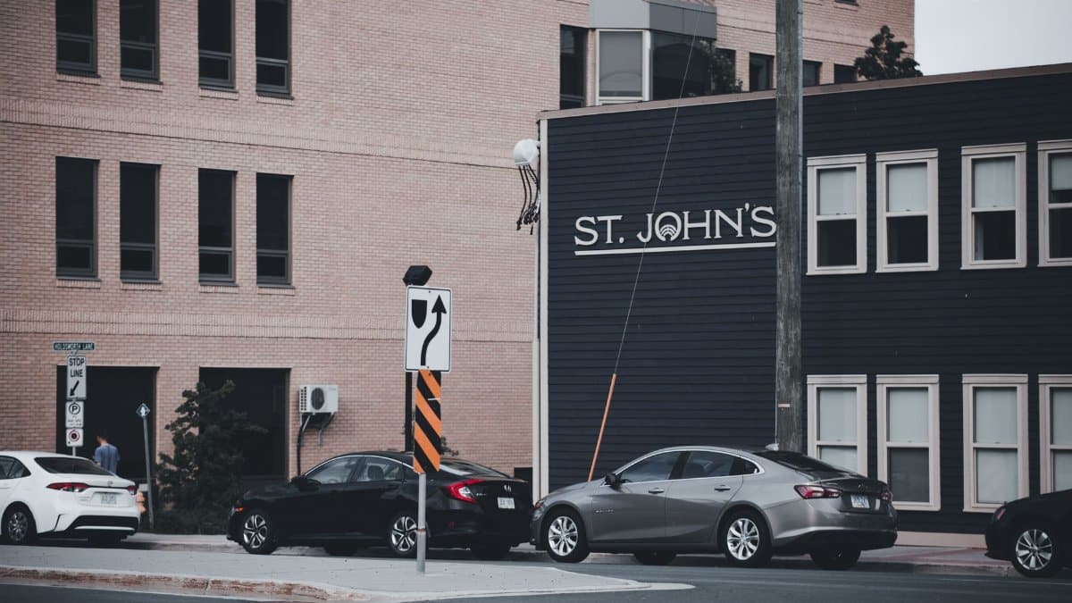 City street view featuring St. John's sign, cars, and urban architecture.