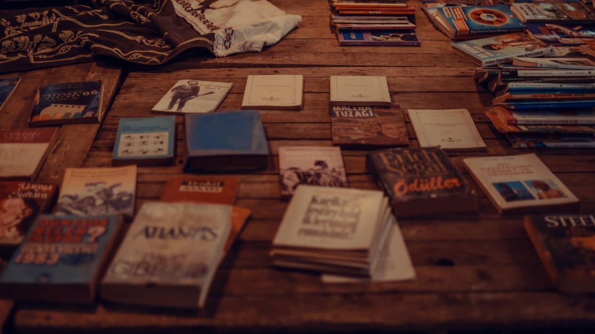 From above of various books and stack of magazines placed on shabby wooden table