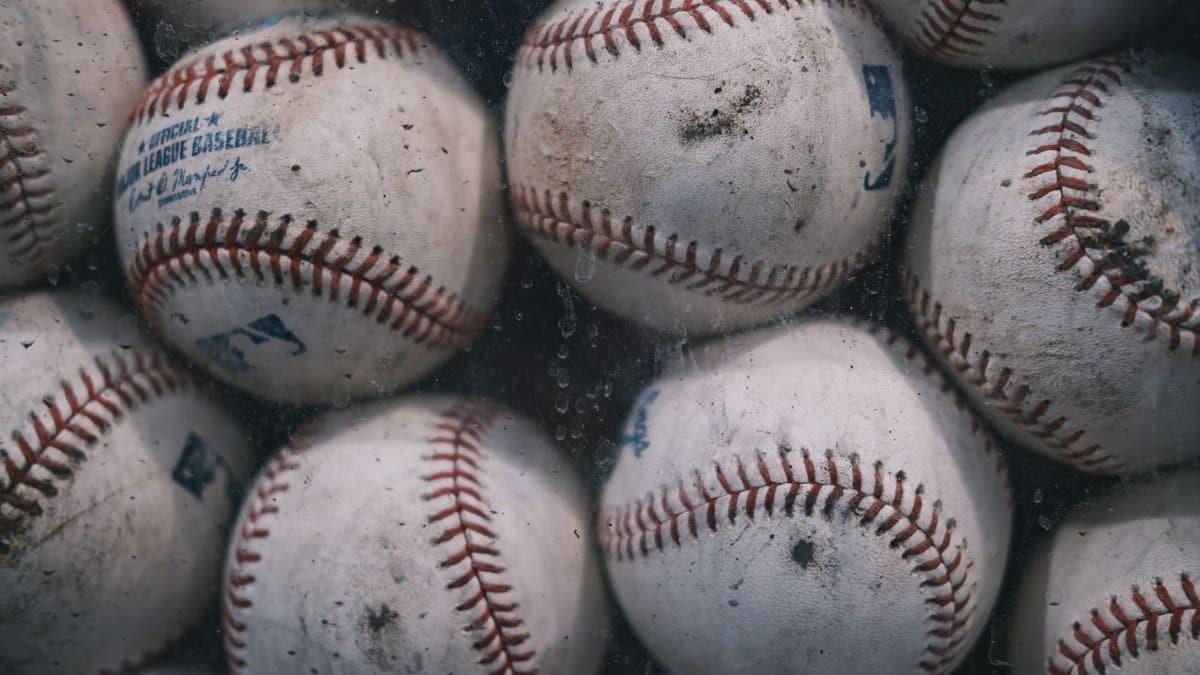 A detailed view of a collection of worn baseballs, showcasing texture and stitching.