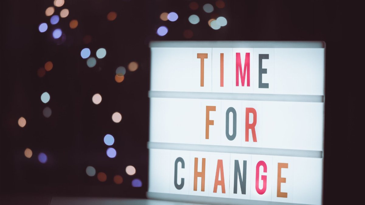 Illuminated lightbox sign displaying 'Time for Change' with a bokeh background, conveying transformation.
