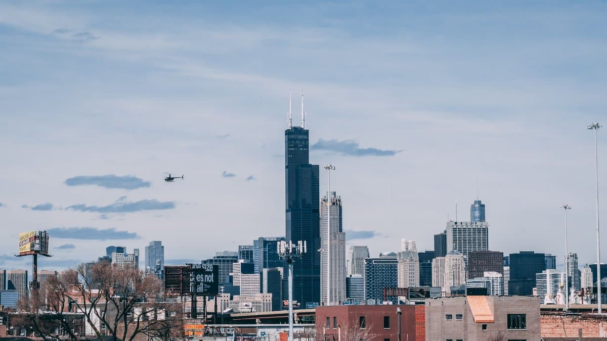 Wide view of Chicago's urban skyline featuring Willis Tower under a clear sky.