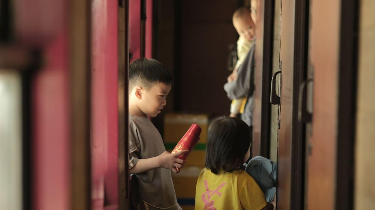 A group of children socialize in a cozy indoor corridor with gentle lighting.