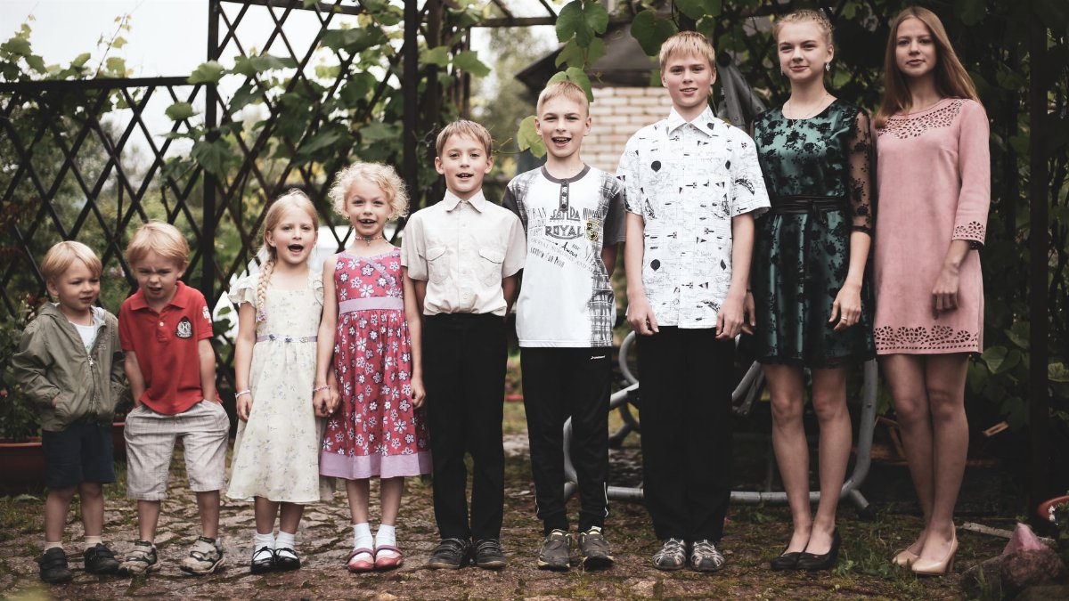 Happy group of children posing in garden setting, showing togetherness and joy.