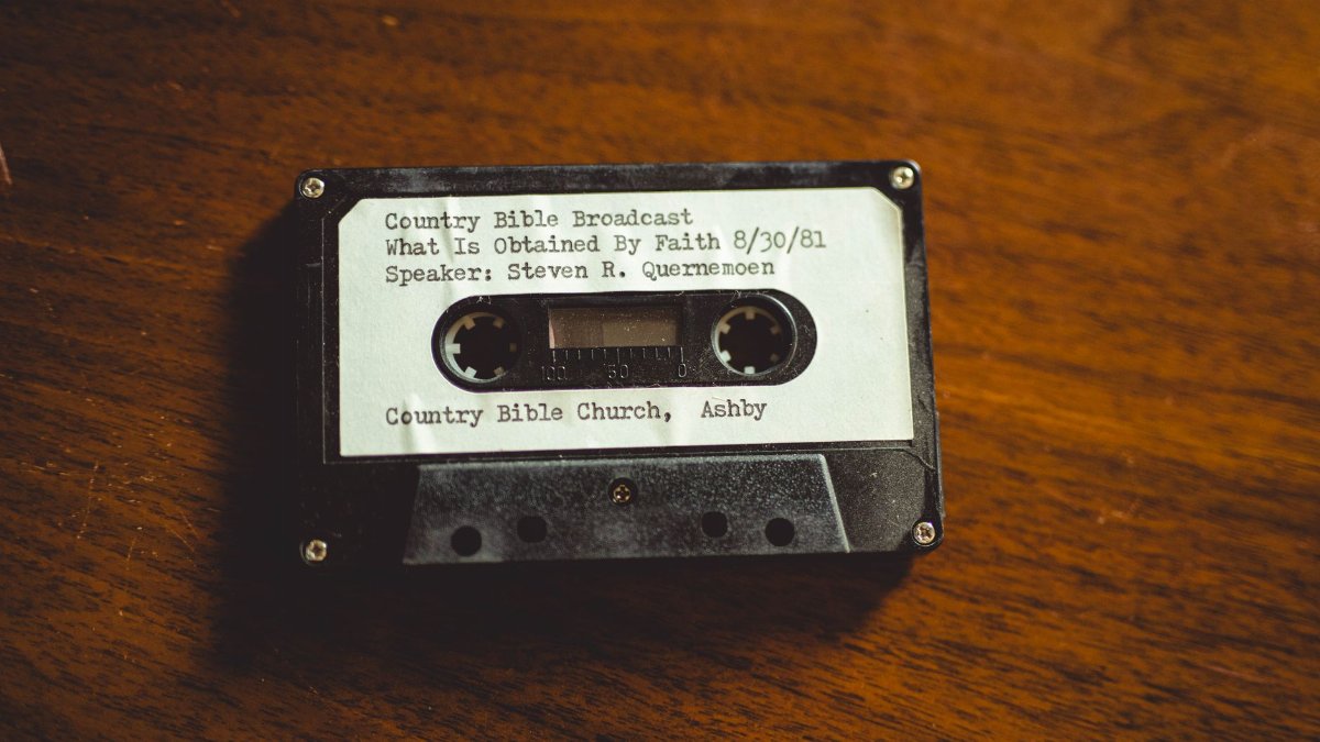 Close-up of a vintage cassette tape labeled with a 1981 Bible broadcast from Ashby, Minnesota.