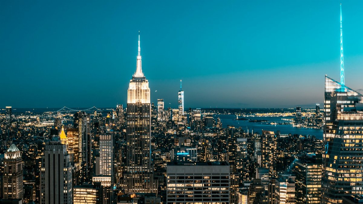 Dazzling New York City skyline glowing at night with iconic skyscrapers and vivid lights.