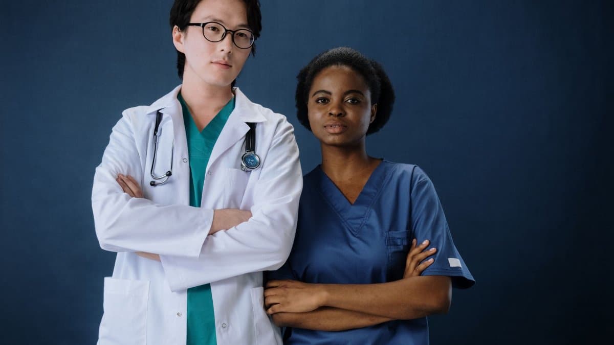 A confident doctor and nurse posing in a studio setting.
