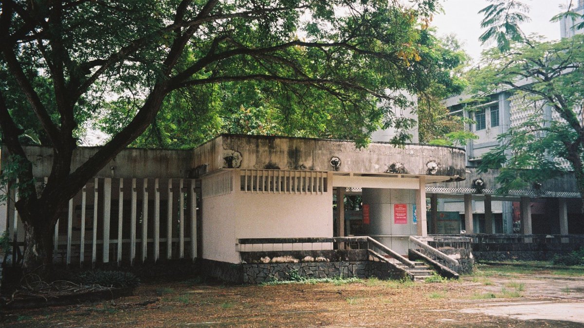 Can Tho University's exterior with lush green trees in an urban setting, Vietnam.