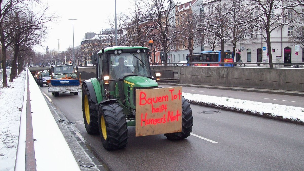 Tractor leading a protest on a snow-covered city street, highlighting hunger issues.
