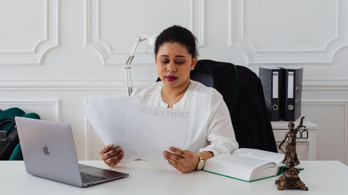Confident businesswoman analyzing contracts at her clean, organized desk.