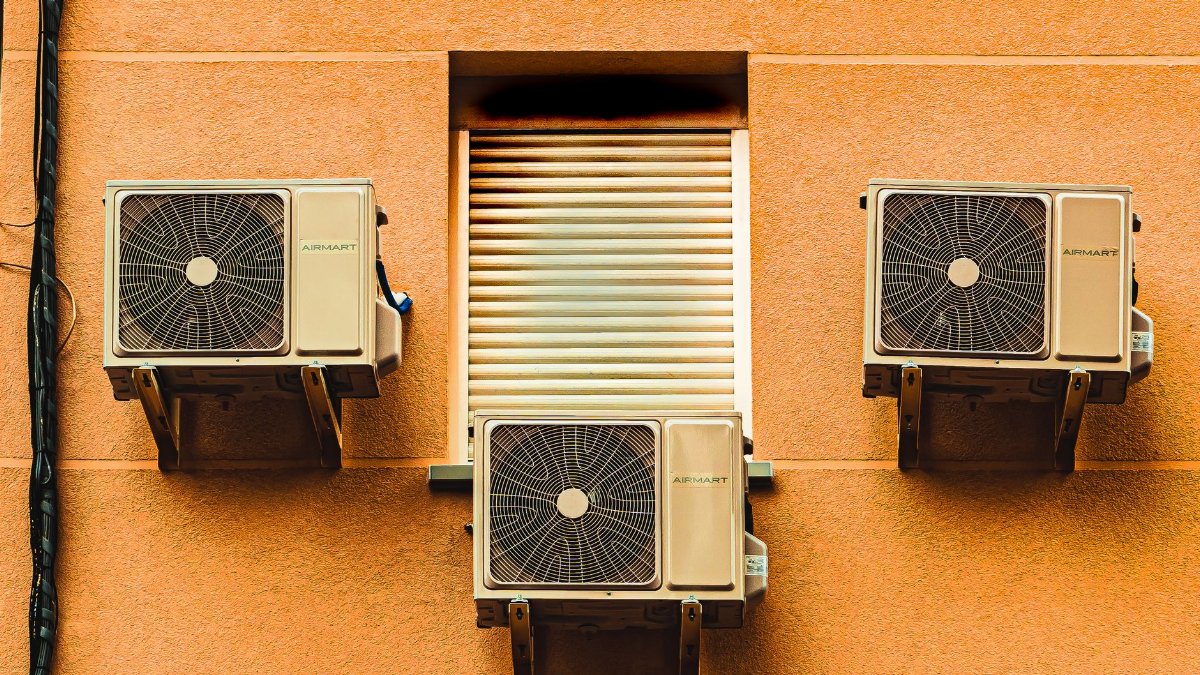 Exterior wall with three air conditioners, showcasing modern architectural elements.
