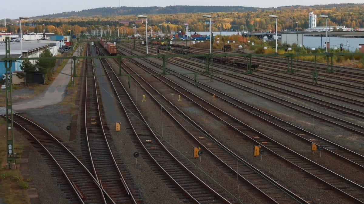 Aerial view of railway tracks in Jönköping, Sweden with autumn foliage, showcasing industrial transportation.