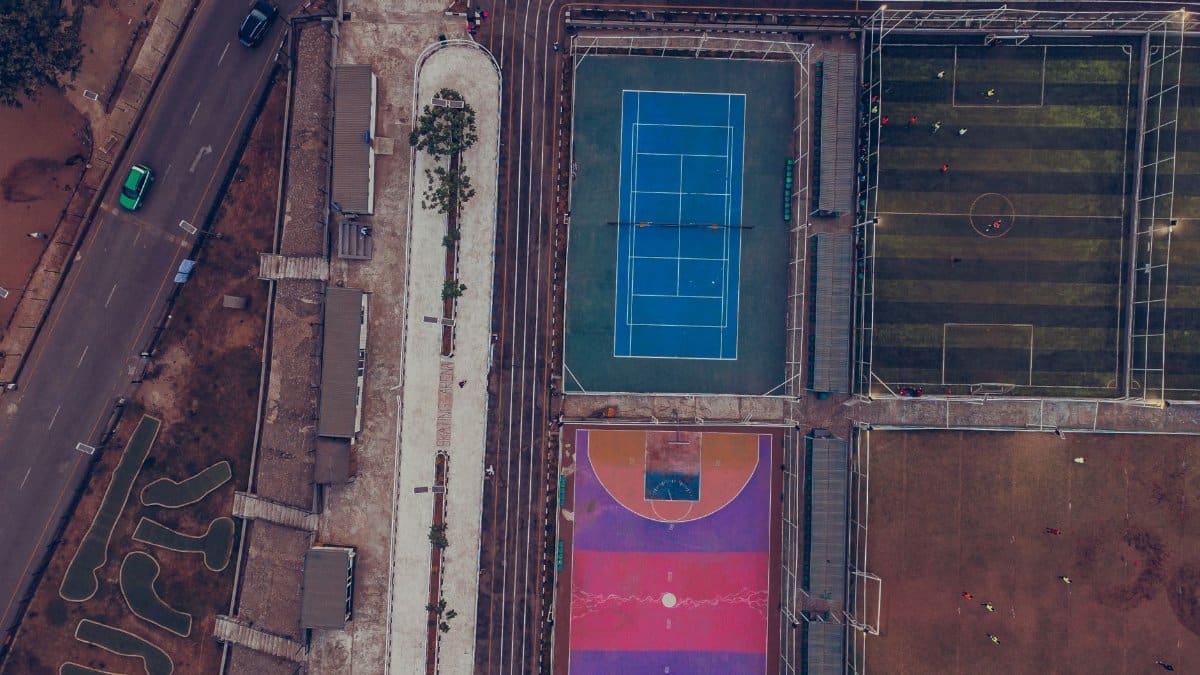 Top-down aerial shot showcasing tennis, soccer, and colorful basketball courts.