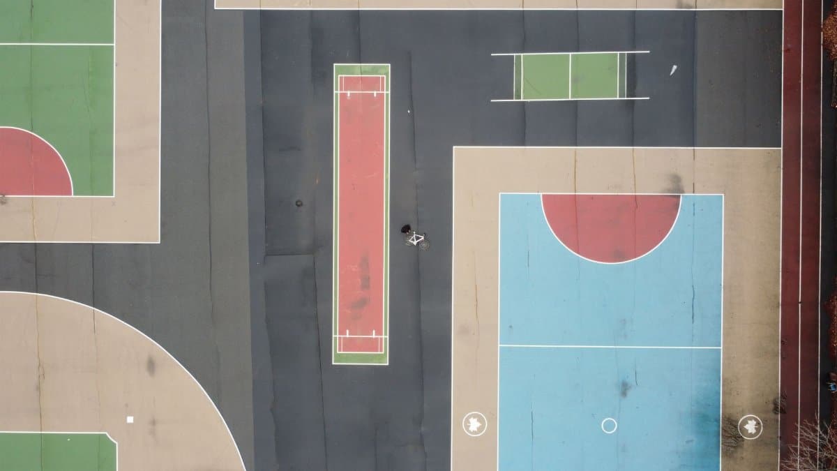 Colorful sports courts captured from above in Brooklyn's urban setting.