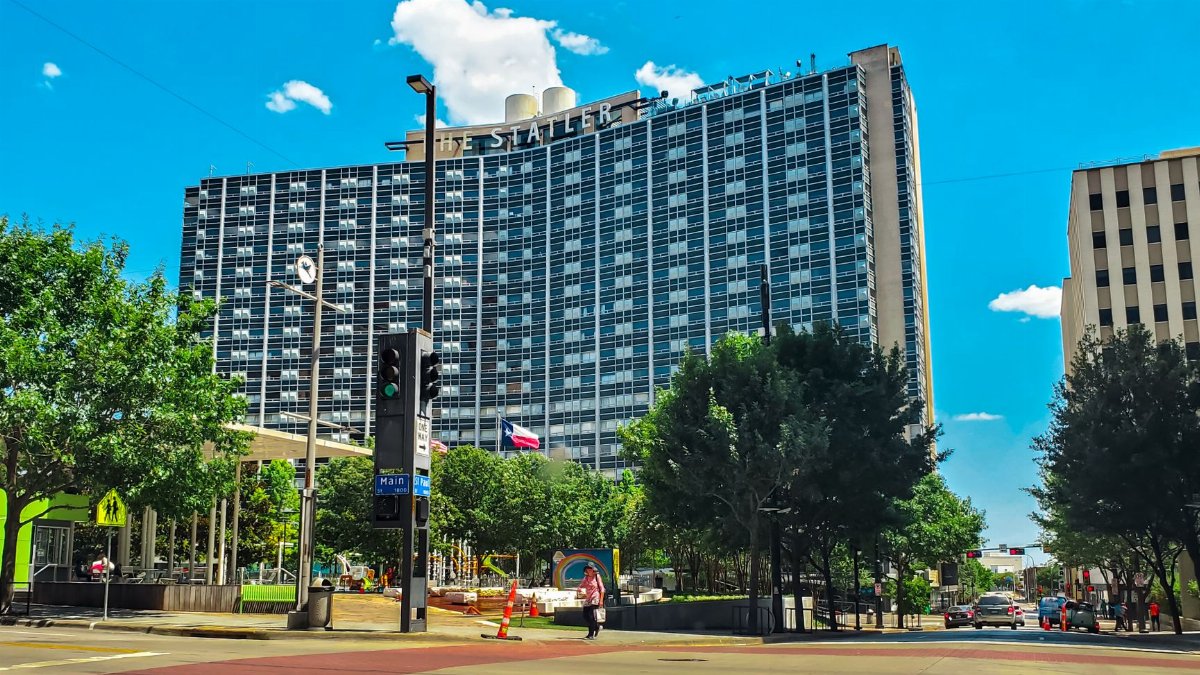 The Statler Hotel in Dallas showcases modern urban architecture under a bright summer sky.