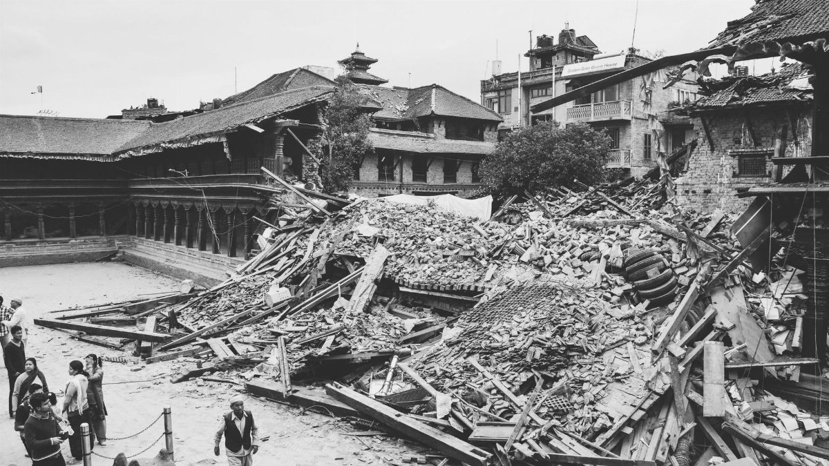 Monochrome image capturing earthquake aftermath in Bhaktapur, Nepal, showing destroyed buildings and debris.