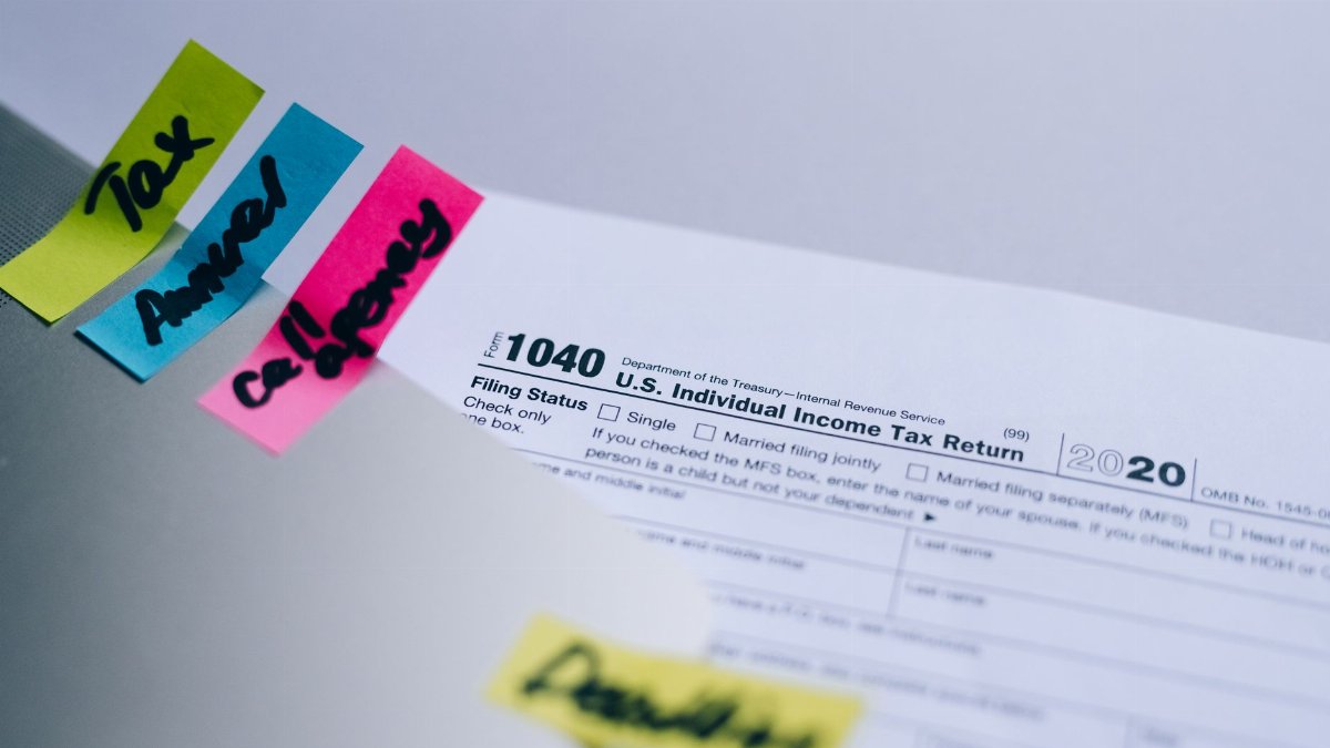 Close-up of 1040 U.S. tax form with colorful sticky notes for organization.