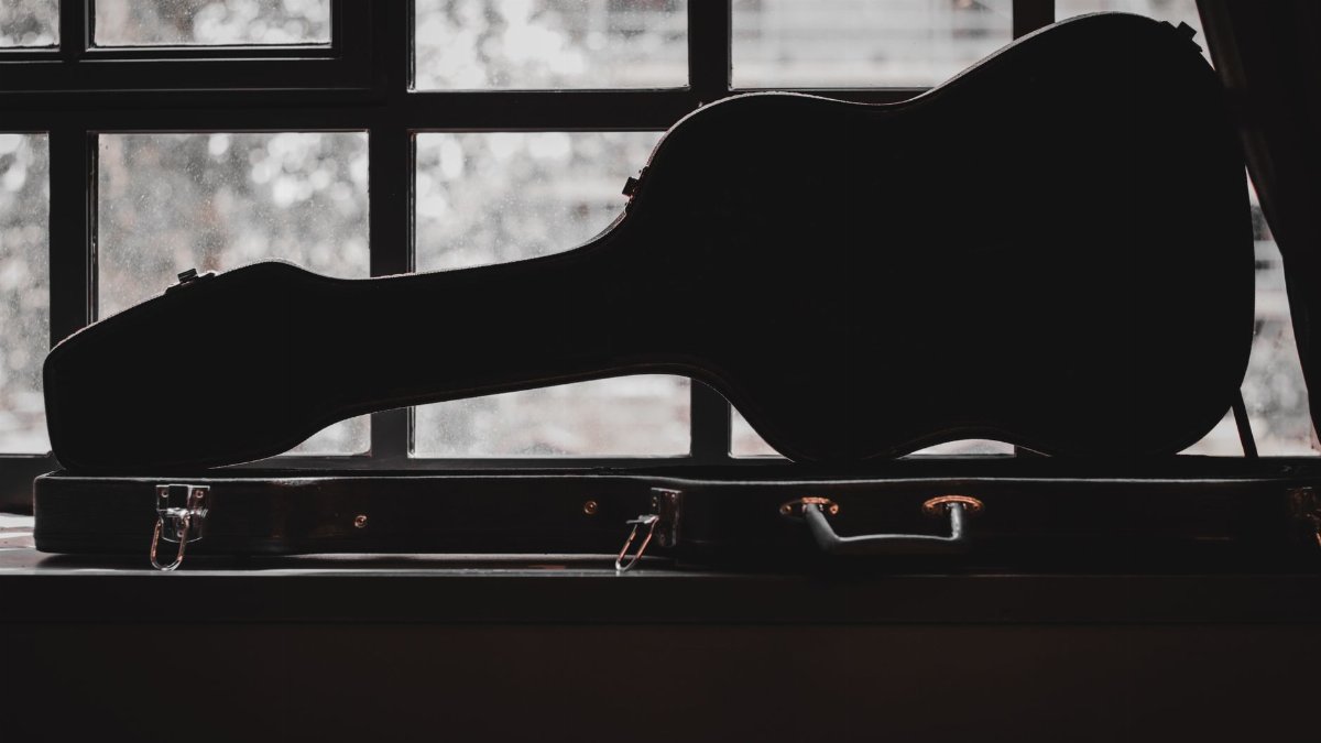 Silhouette of a violin case in front of a window, showcasing musical elegance.