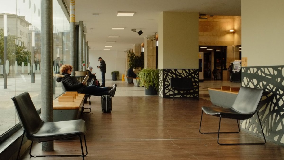 Casual modern seating area with people waiting indoors.
