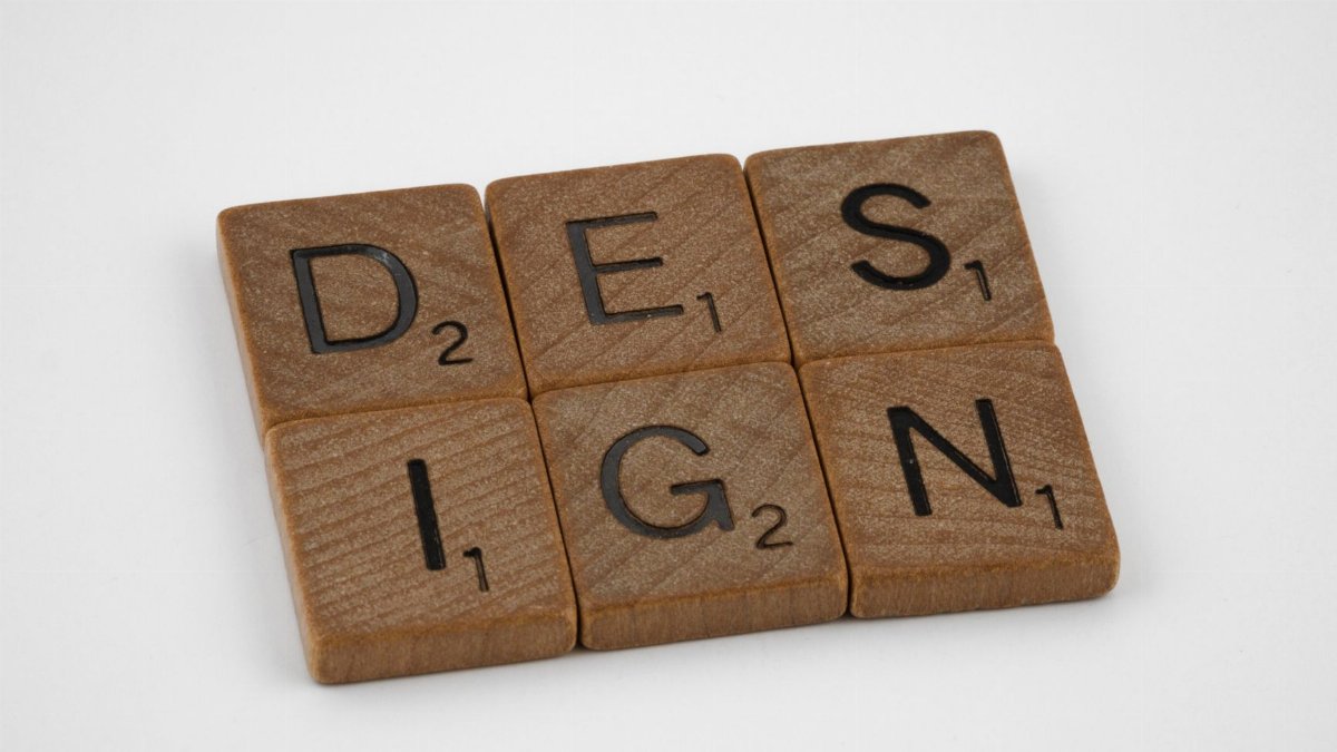 Scrabble tiles forming the word 'DESIGN' on a white background, highlighting creativity.