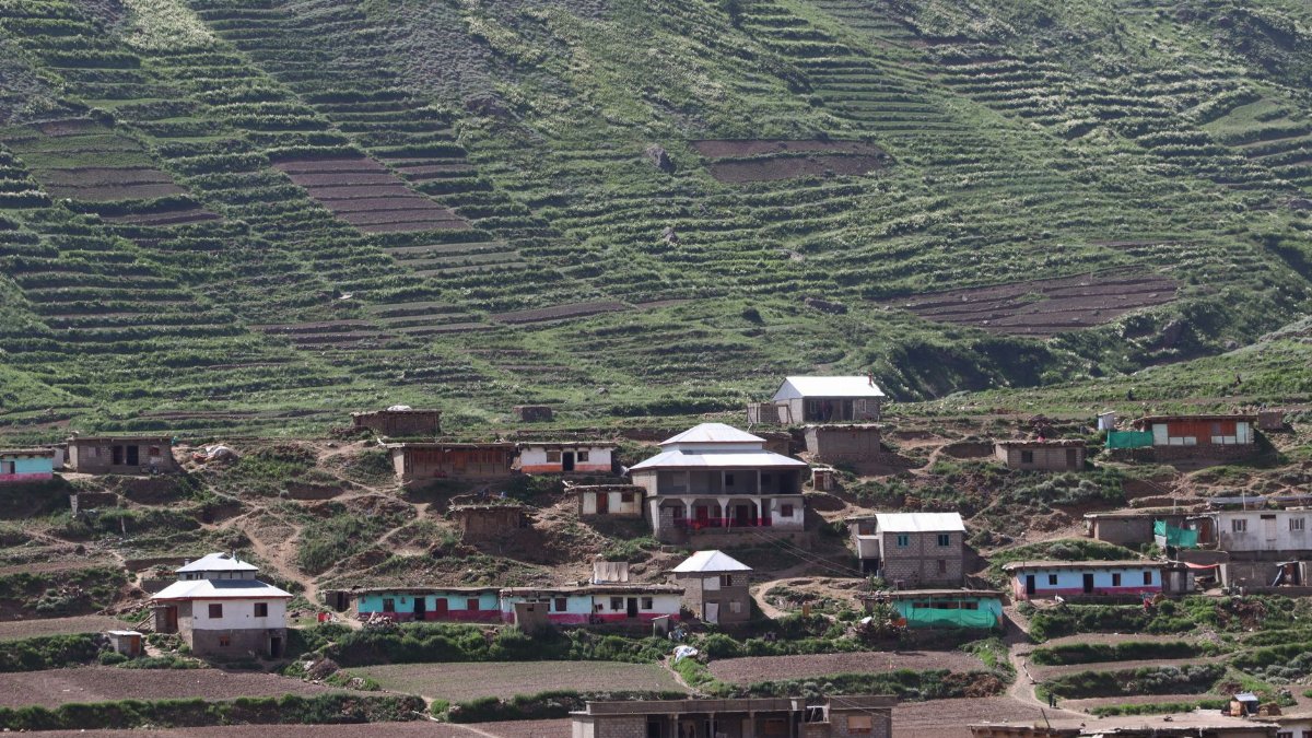 Beautiful view of a mountain village with terraced agricultural fields and traditional houses.