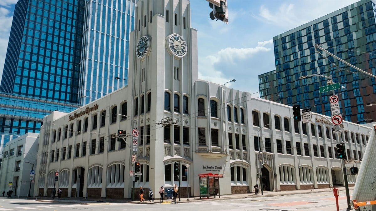 San Francisco Chronicle Building with clock tower under a clear blue sky in downtown San Francisco.
