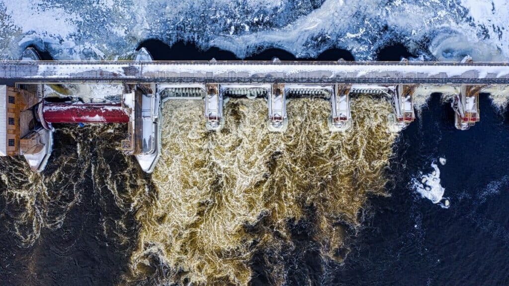 Dramatic aerial shot of a frozen dam with rushing water in winter in Minnesota.