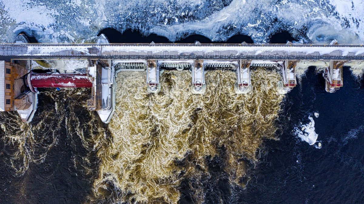 Dramatic aerial shot of a frozen dam with rushing water in winter in Minnesota.