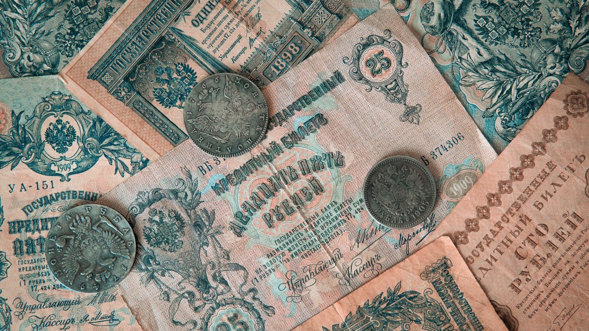 Collection of vintage Russian banknotes and coins featuring intricate designs.