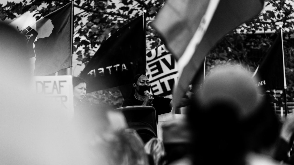 Black and white image of a woman speaking at a BLM protest in Los Angeles.