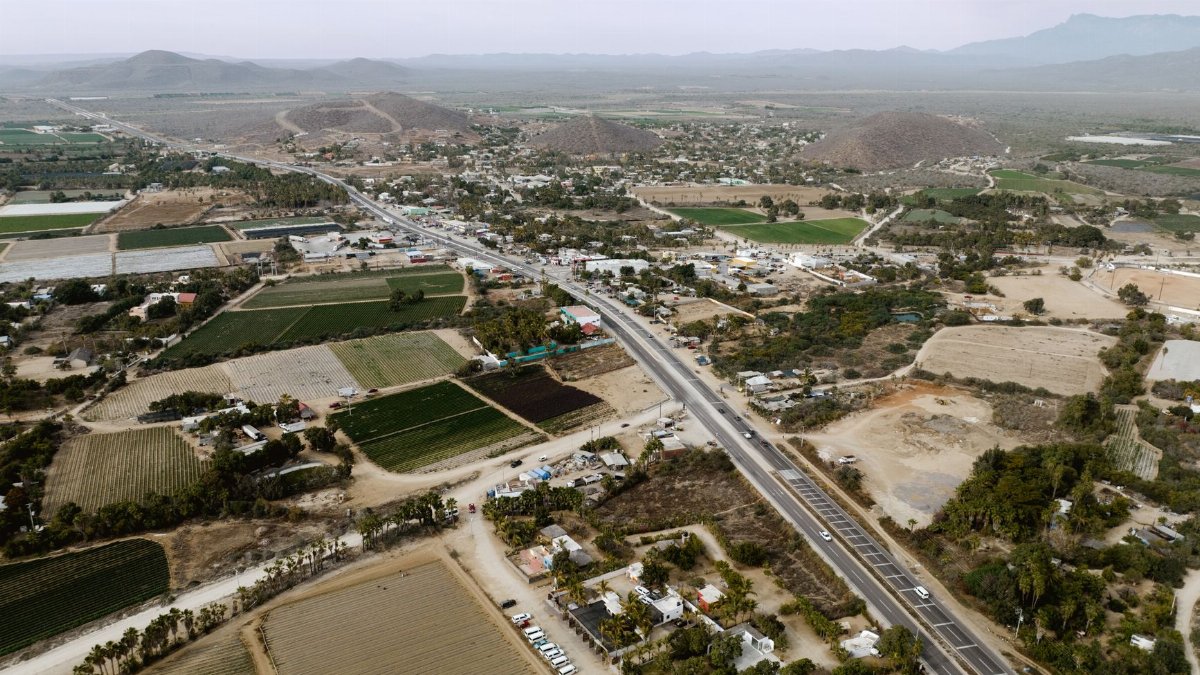 Scenic aerial view of El Pescadero, BCS, Mexico showcasing farmland, roads, and mountains.