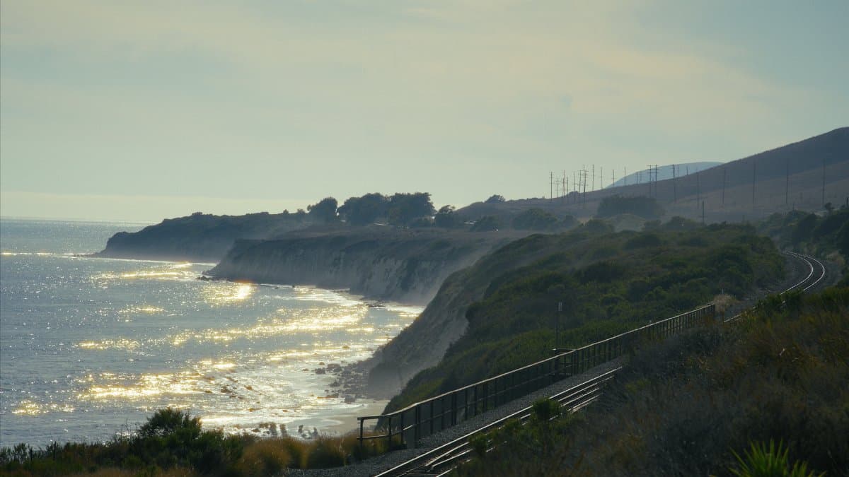 Captivating view of Gaviota's coastline with sparkling ocean and train tracks at sunset.