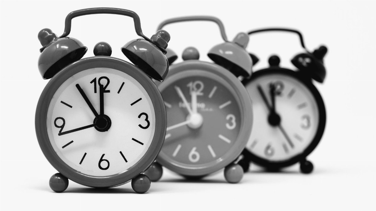 Monochrome image of three vintage alarm clocks highlighting the passage of time.