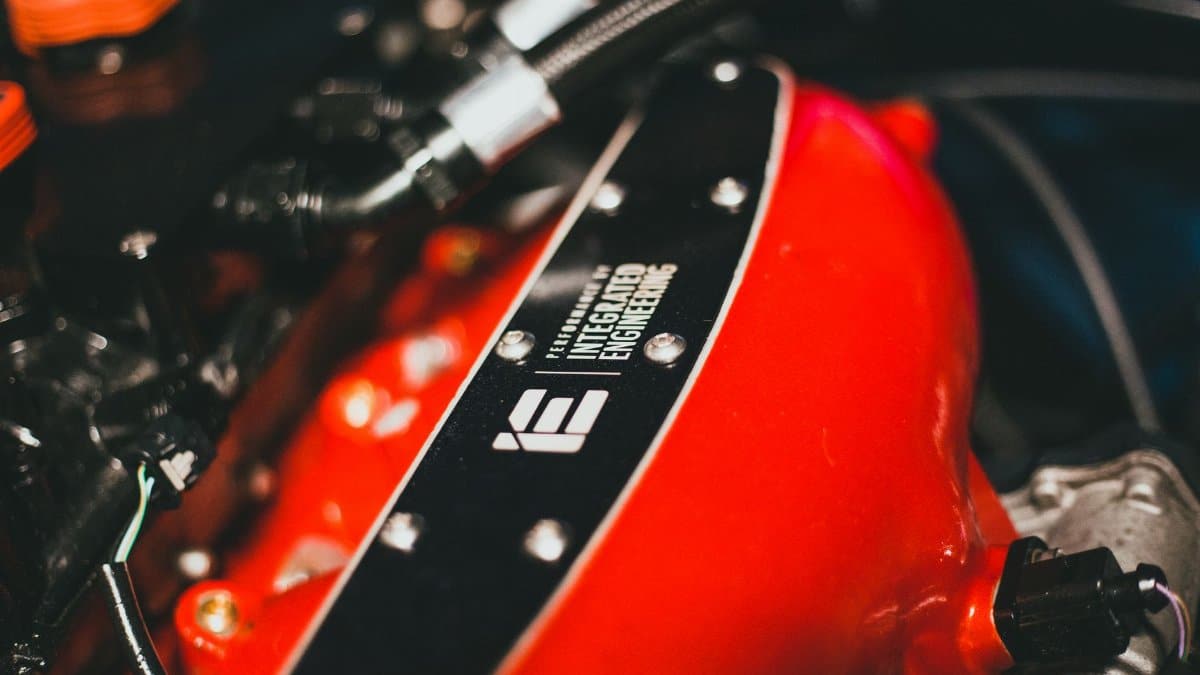 Detailed view of a red engine part with Integrated Engineering branding, showcasing automotive design.