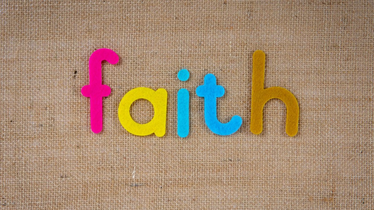 Brightly colored text spelling 'faith' on a textured burlap material, conveying spirituality and belief.