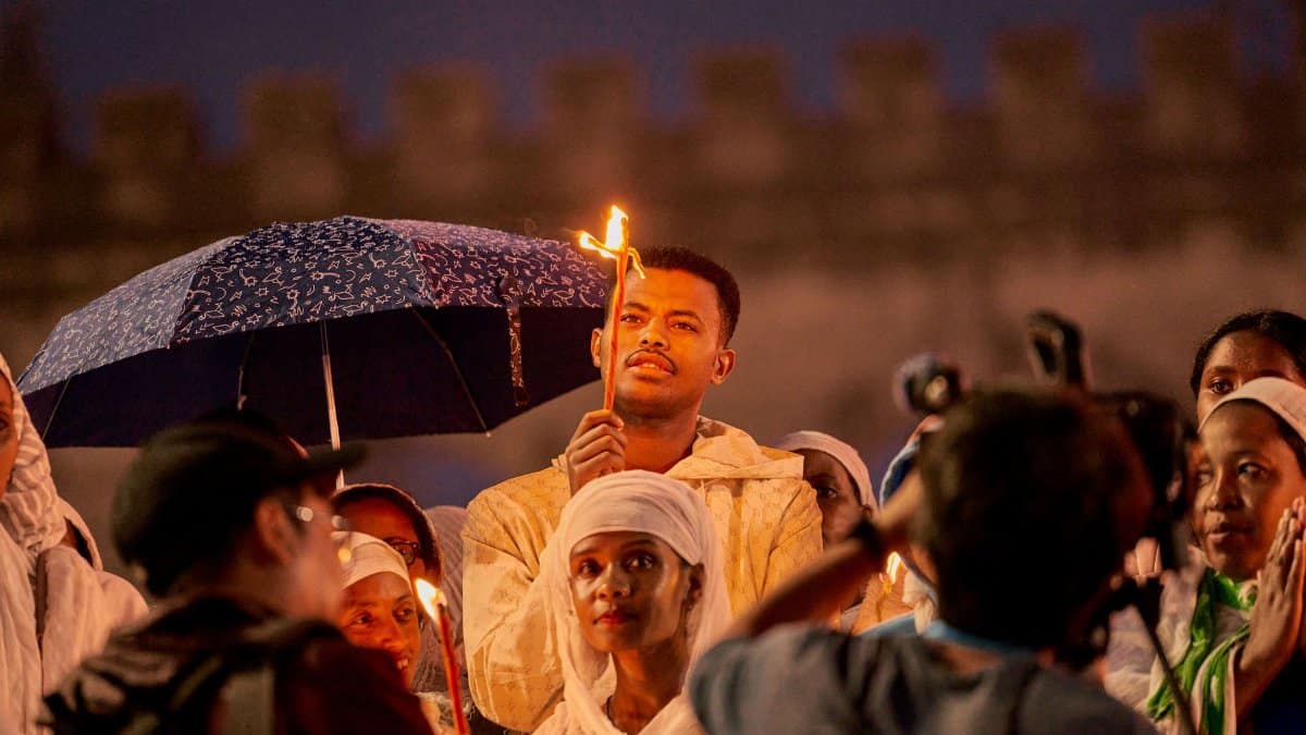 People gather for an Ethiopian candlelight vigil, highlighting cultural heritage.